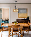 Straight Up Gorgeous Farmhouse Chandelier Featuring Three Woven Rattan Shades hanging above a wooden dining table in a cozy setting.