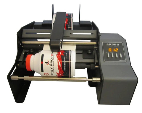 Hustle Ready Semi Automatic Label Applicator For Cylindrical Bottles Cans Jars And Tubes With No Sweat Setup And Smooth Operation Up To 1200 Per Hour For Production Lines with a cylindrical bottle in operation.