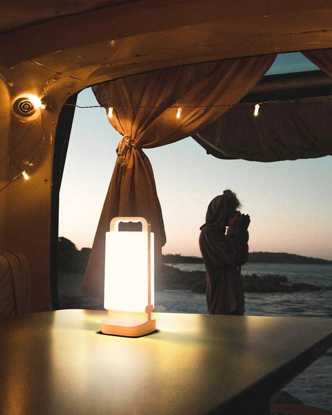 Solar Camping Lantern With 6000mAh Rechargeable Battery Up To 80 Hours Of Light illuminating a camper van table at dusk