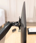 Hassle Free Quick Release VESA Mount Adapter Bracket Kit With Removable Plate For LCD Monitors And TV Screens attached to a TV arm.