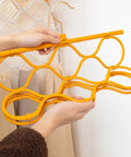Foldable Scarf Organizer Rack With 18 Slots For Closet Storage And Necktie Display held up in hands, bright orange durable design.