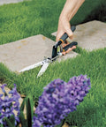 5 Inch Serrated Blade Grass Shears with Power Lever Technology trimming lawn edges near flower bed