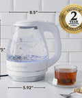1.5 Liter Glass Electric Kettle With Blue Led Glow Rapid Boil Auto Shutoff, showing boiling water and tea set on countertop.