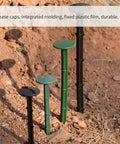 50 Pack Landscape Fabric Stakes Black Plastic Anchoring Spikes 6.3 Inch installed in dirt with thorn design for garden use