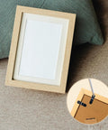 Front view of a wooden picture frame with white mat; shows 100 black metal turn-button fasteners and screws for frame backing
