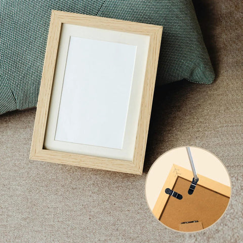 Front view of a wooden picture frame with white mat; shows 100 black metal turn-button fasteners and screws for frame backing