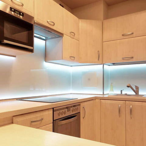 Modern kitchen featuring sleek cabinetry, minimalist design, and under-cabinet lighting with a clean, light wood finish.