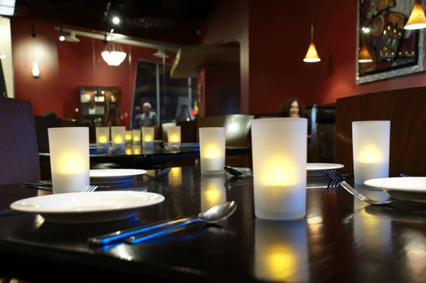 Rechargeable Tealights Flickering Flameless Candles With Charging Base And AC Adapter 12 Pack LED Tealight Set on restaurant table