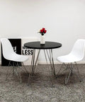Minimalist round black table with white chairs, suitable for use with Black 3/4 In X 100 Ft Center Barb Tee Molding Roll for DIY projects.