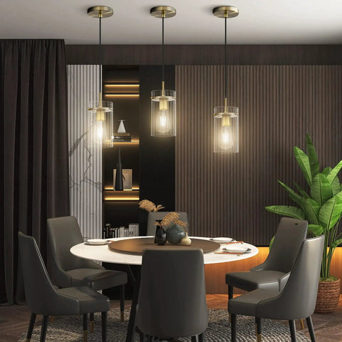 Three Pack Modern Mini Pendant Lights In Brushed Brass With Clear Stripe Glass Shade Hanging Above Dining Room Table
