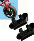 Black pedal stabilizers for tricycle with adjustable straps, shown installed and separately, for kids with special needs.