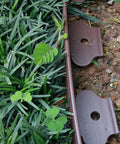 40 Ft Brown Landscape Edging Kit With 40 Spiral Stakes next to grass showing installation and defining border use
