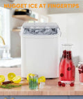 Grab And Go Countertop Ice Maker With Handle Portable Ice Machine Delivers Ice In Six Minutes, Nine Bullet Ice Cubes Per Batch With Basket And Scoop, Produces About 26 Lbs Per Day, Auto Cleaning, Perfect For Home Kitchen RV Camping White on kitchen counter with drinks and lemons