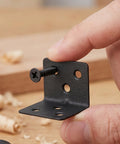 Close-up of 12 Pack L Shape Corner Braces With Screws Heavy Duty Cold Rolled Steel 90 Degree Shelf Supports held by hand