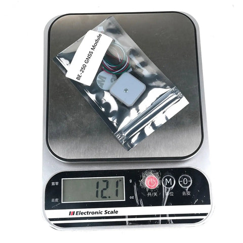Beitian GPS GNSS Positioning Module Plug And Play With M10050 Chip For Fixed Wing FPV Racing Drones on electronic scale showing weight.