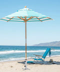 Beach scene with striped umbrella using Removable Inground Umbrella Stand Anchor With Four Spikes Metal Ground Stake For Beach Sand