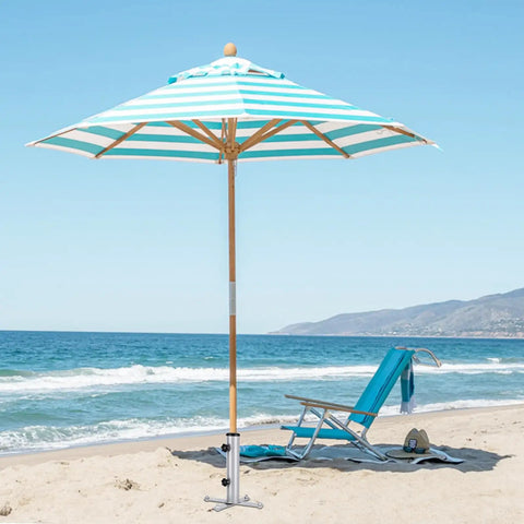 Beach scene with striped umbrella using Removable Inground Umbrella Stand Anchor With Four Spikes Metal Ground Stake For Beach Sand
