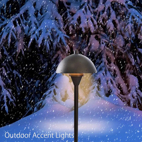 Snow-covered Go To Low Voltage G4 LED Path Lights For Outdoor Landscape Lighting in oil rubbed bronze glowing in winter garden.