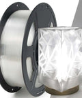 Crystal Clear PETG Filament 1.75mm 1kg for 3D Printing next to a glasslike lampshade.