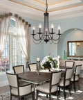 Five Light Farmhouse Chandelier In Black With Classic Candle Ceiling Light Fixture in a cozy dining room setting.