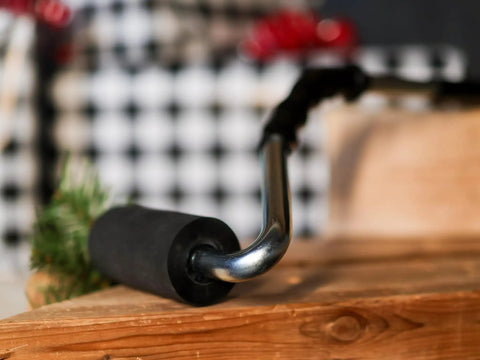 Pro Grade Heavy Duty High Pressure Rubber J Roller with curved handle on wooden surface, ideal for laminate and veneer glue application.