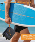 Person holding a blue stand up paddleboard with Portable Rechargeable Electric SUP Pump for Stand Up Paddleboards on the go.