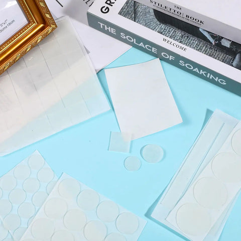 Anti Slip Silicone Pads For Glass Tables With 132 Pcs Adhesive Dots and Grippers near books and frame on blue surface