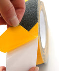 Heavy Duty Anti Slip Grip Tape 6 Inch By 30 Ft Black And Yellow Striped 80 Grit Aluminum Oxide in close-up view being peeled