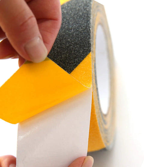 Heavy Duty Anti Slip Grip Tape 6 Inch By 30 Ft Black And Yellow Striped 80 Grit Aluminum Oxide in close-up view being peeled