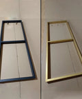 Badass Heavy Duty Floating Shelf Brackets in black and gold finishes displayed on a flat surface, highlighting sturdy design and size.