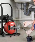 100 Foot Auto Feed Drain Snake With Three Quarter Inch Electric Drain Auger in use near plumbing to clear clogs.