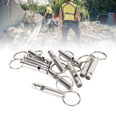 Versatile Emergency Whistle Kit 10 Pack Alloy Safety Whistles With Keychains scattered on debris background