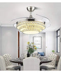 42 Inch Retractable Blade Ceiling Fan Featuring Glowing Crystal Chandelier And Smart Remote Controls For Tunable Led Lights In A Legit Bedroom Or Dope Living Room Vibe over a dining table in a modern setting.