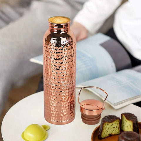 Copper Water Bottle With Easy Temperature Control And Built Tough Leakproof Insulated Design For Men And Women, gold finish, on table.
