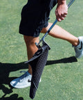Golfer carrying club with Premium Magnetic Golf Towel With Brush Groove Cleaner And Clip Microfiber Waffle Towel for your golf bag