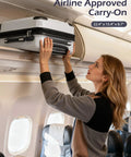 Person placing Durable Lightweight Carry On Luggage With PC Plus ABS Hard Shell, Dual Spinner Wheels into overhead bin on airplane