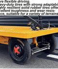 Huge Heavy Duty Electric Platform Truck Cart That Folds Like A Dream For Moving Groceries And Warehouse Gear With Slip Resistant Surface Holding Up To 2K Lbs tire close-up showing durable solid rubber construction for various terrains.