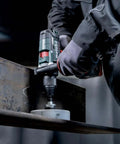 Close-up of Tough As Nails 18V Cordless Power Drill With Supra SK Drill Chucks working on steel during heavy drilling.