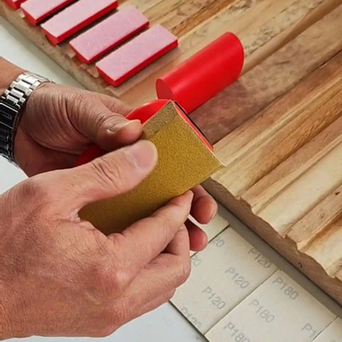 Close-up of person using All-In-One 16-Piece Hook And Loop Sanding Block Kit With 40 Sandpaper Sheets on wood surface