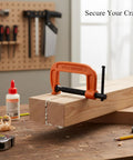 Heavy Duty Iron G Clamp With Massive 3 Inch Jaw holding two wooden pieces together on a workbench for woodworking projects.