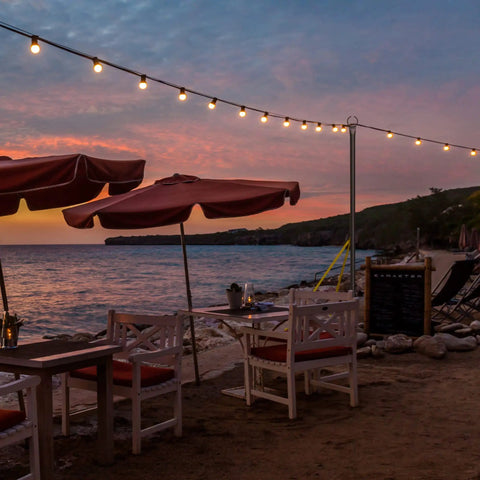 Outdoor String Light Poles 9 Ft Two Function Poles With Fork Bases And Fence Brackets 2 Pack on beach with sunset view