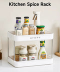 Kitchen spice rack with two tiers holding various spice jars and mustard bottle, with a white ABS frame on countertop.