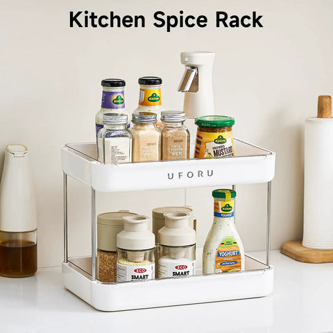 Kitchen spice rack with two tiers holding various spice jars and mustard bottle, with a white ABS frame on countertop.