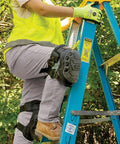 Worker climbing ladder wearing All Day Comfort Hinged Gel Knee Pads With Slip Resistant Rubber Caps and adjustable straps.