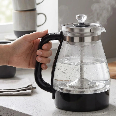 1 Liter Glass Electric Kettle With Keep Warm Function, Rapid Boil Tech, Auto Shut Off Safety, Bpa-Free Borosilicate Build, And An Easy Pour Spout For Your Daily Must Have Morning Routine, held in hand with steam rising.