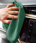 Hand using Heavy Duty Shop Towels 50 Pack Green Terry Cloth Rags For Car Detailing And Home Cleaning Highly Absorbent Reusable Washable Towels