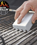 Hand using Grillin Stone Grill Cleaning Brick Block for BBQ Griddle and Racks Easy Scrubbin Stone Cleaner on barbecue grill grates