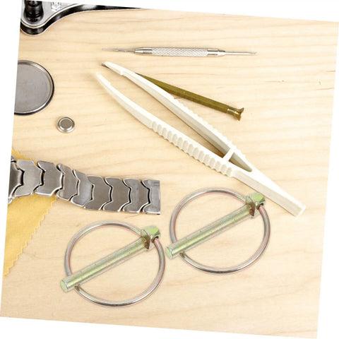 Heavy Duty Lynch Pin Kit With Rings Eight Piece Assortment For Trailers, Trucks And Mowers Galvanized Steel Safety Pins For Secure Attachment And Quick, Reliable Locking In Tough Jobs. Assorted pins on wood