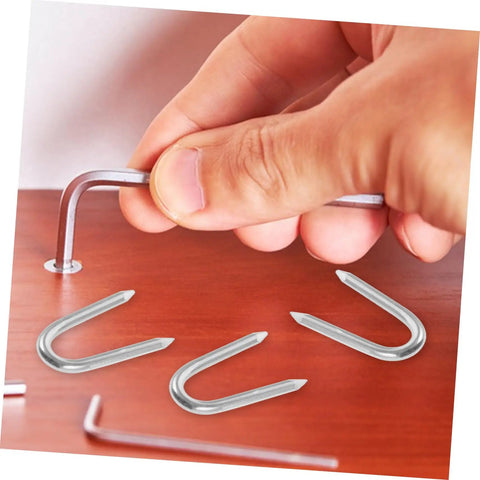 Hand installing 50 Pack U Shaped Fence Staples For Quick Install And Strong Hold Durable Metal Garden Stakes For Fences Landscaping And DIY Projects