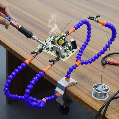 No Hands Soldering Clamp Aid With Four Alligator Clips Wire Clip Holder in use for circuit board soldering on wooden table